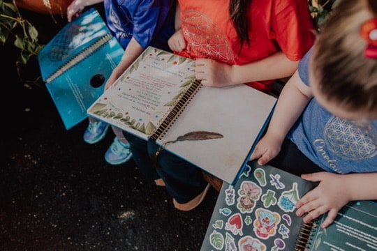 Children reading a page marked with the feather bookmark
